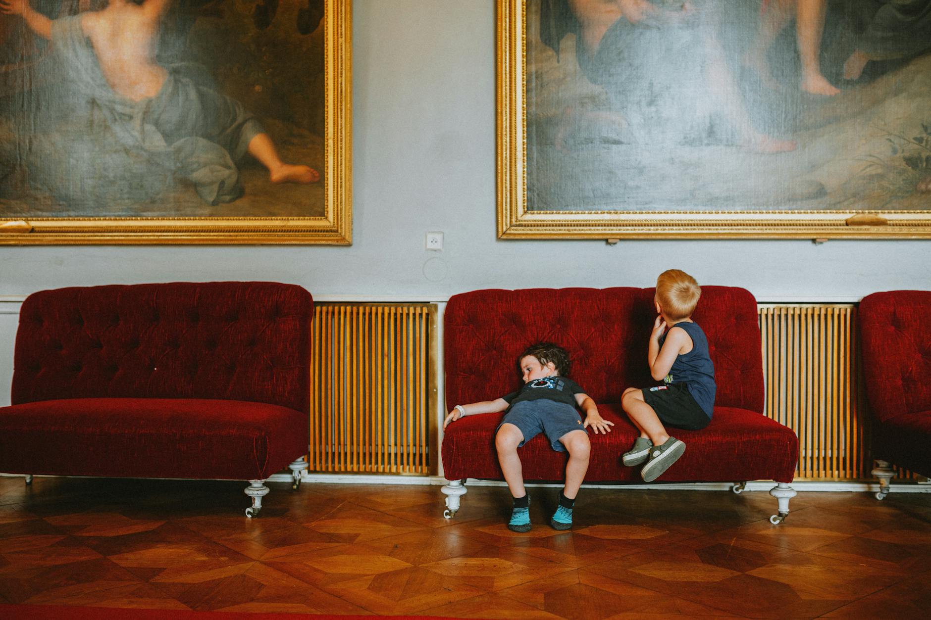 Dwoje dzieci na czerwonej sofie w muzeum w Budapeszcie