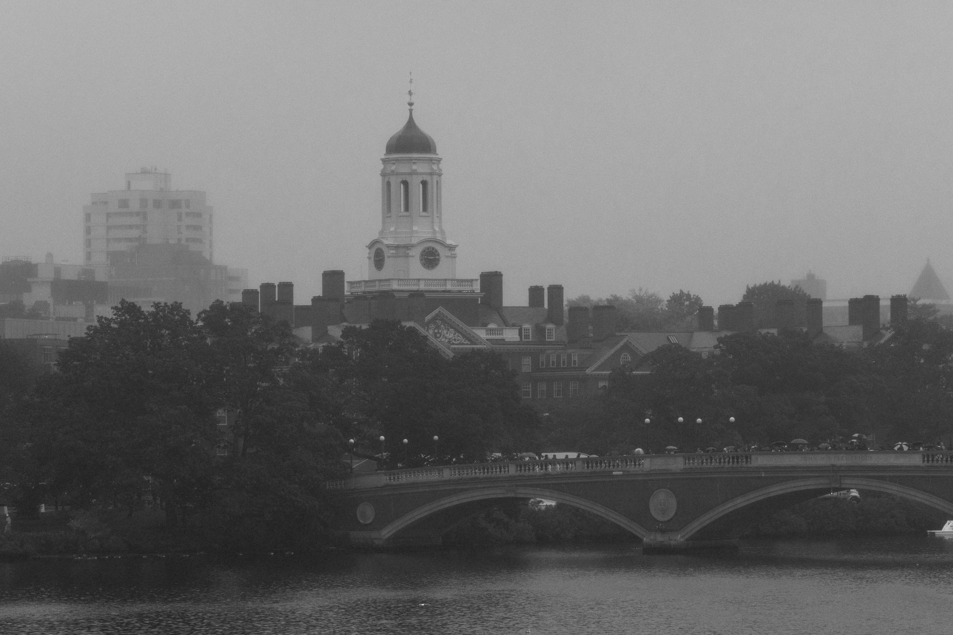 Mglista panorama Harvardu z wieżą zegarową i mostem Weeks Footbridge