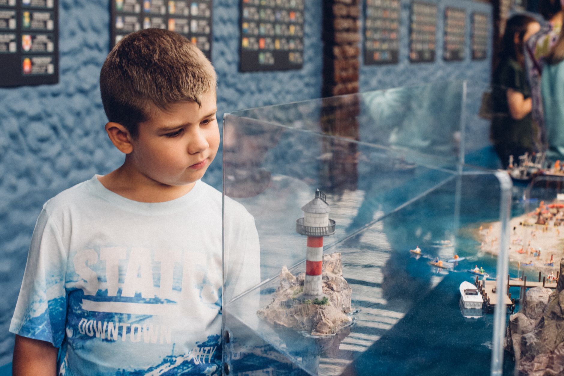Dziecko ogląda makietę latarni morskiej w muzeum na Pomorzu